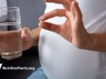 pregnant woman holding pill
