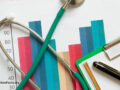 A clipboard, pen, and graphs with stethoscope