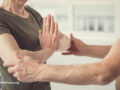 Two people helping each other with yoga poses